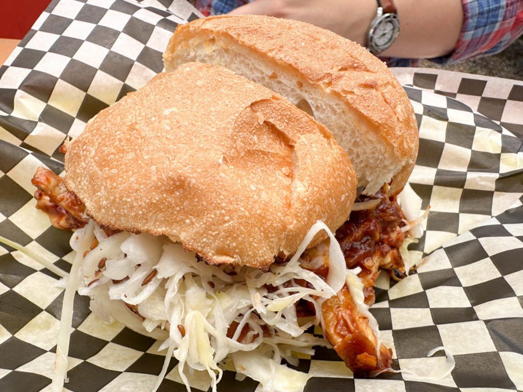 A savory sandwich filled with veggie pulled pork and coleslaw is placed on a checkered paper liner. Ideal for a quick bite, this dish can be a tasty highlight in your Montreal itinerary for 2 days.


